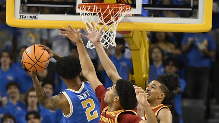 Feb 24, 2026; Los Angeles, California, USA; UCLA Bruins guard Donovan Dent (2) drives to the basket while guarded by Southern California Trojans forward Jacob Cofie (6) and guard Chad Baker-Mazara (4) during the first half at Pauley Pavilion presented by Wescom Financial. Mandatory Credit: Robert Hanashiro-Imagn Images