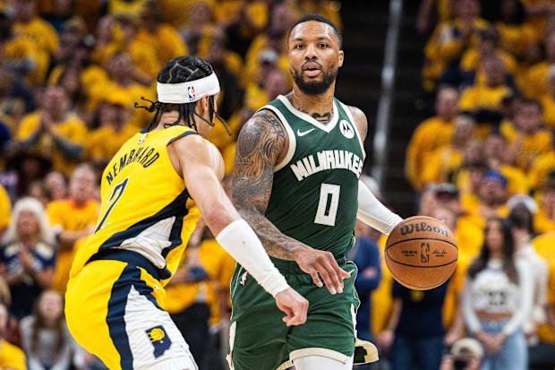 Milwaukee Bucks guard Damian Lillard dribbles the ball while Indiana Pacers guard Andrew Nembhard defends in 2023-24.