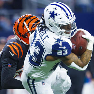 Dec 9, 2024; Arlington, Texas, USA; Dallas Cowboys running back Rico Dowdle (23) runs with the ball as Cincinnati Bengals cornerback DJ Ivey (38) defends during the first quarter at AT&T Stadium. Mandatory Credit: Kevin Jairaj-Imagn Images