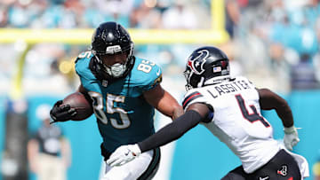 Sep 21, 2025; Jacksonville, Florida, USA; Jacksonville Jaguars tight end Brenton Strange (85) runs the ball against Houston Texans cornerback Kamari Lassiter (4) during the third quarter at EverBank Stadium. Mandatory Credit: Morgan Tencza-Imagn Images
