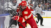 Apr 10, 2025; St. Louis, Missouri, UNITED STATES; Denver Pioneers forward Sam Harris (12) checks Western Michigan Broncos forward Matteo Costantini (25) in overtime during the Frozen Four college ice hockey national semifinals at Enterprise Center. Mandatory Credit: Jeff Curry-Imagn Images