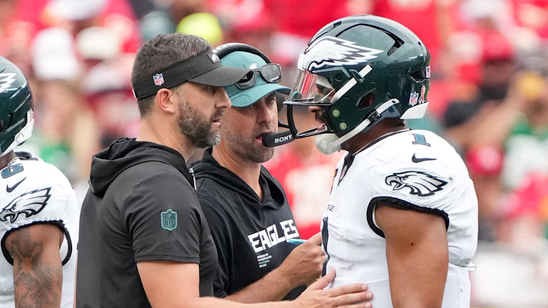 Sep 14, 2025; Kansas City, Missouri, USA; Philadelphia Eagles head coach Nick Sirianni and offenisve coordinator Kevin Patullo speak with Philadelphia Eagles quarterback Jalen Hurts (1) during the second quarter of the game against the Kansas City Chiefs at GEHA Field at Arrowhead Stadium. Mandatory Credit: Denny Medley-Imagn Images