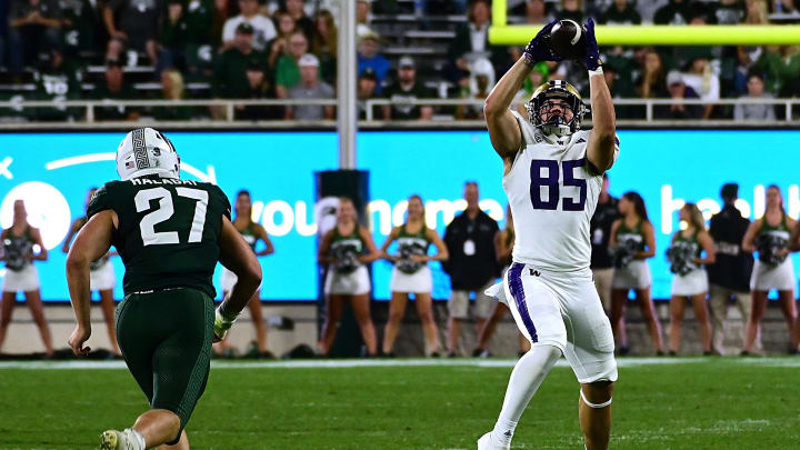 Sep 16, 2023; East Lansing, Michigan, USA;  Washington Huskies tight end Josh Cuevas (85) pulls in a pass against Michigan State Spartans linebacker Cal Haladay (27)   in the third quarter at Spartan Stadium. Mandatory Credit: Dale Young-USA TODAY Sports