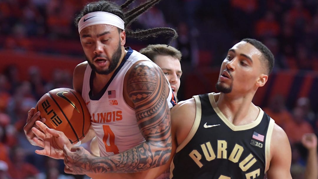 Mar 7, 2025; Champaign, Illinois, USA;  Illinois Fighting Illini guard Kylan Boswell (4) drives the ball as Purdue Boilermakers forward Trey Kaufman-Renn (4) reaches in during the second half at State Farm Center. Mandatory Credit: Ron Johnson-Imagn Images
