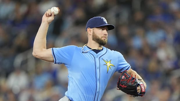Tampa Bay Rays starting pitcher Adrian Houser throws in a blue jersey and hat