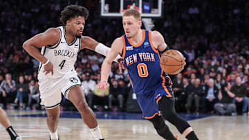 Mar 23, 2024; New York, New York, USA;  New York Knicks guard Donte DiVincenzo (0) looks to drive past Brooklyn Nets guard Dennis Smith Jr. (4) in the fourth quarter at Madison Square Garden. Mandatory Credit: Wendell Cruz-Imagn Images