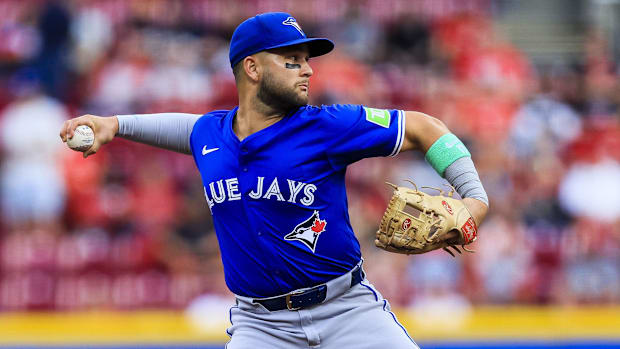 Blue Jays shortstop Bo Bichette (11) throws to first for an out during a game.