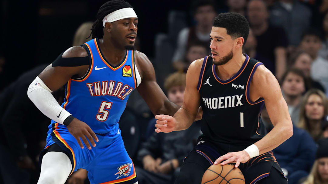 Jan 4, 2026; Phoenix, Arizona, USA; Oklahoma City Thunder guard Luguentz Dort (5) defends against Phoenix Suns guard Devin Booker (1) at Mortgage Matchup Center. Mandatory Credit: Mark J. Rebilas-Imagn Images