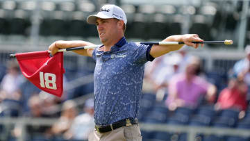 Justin Thomas holds the 18th hole flagstick during a practice round for the 2024 U.S. Open.