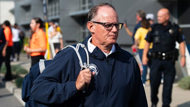 Penn State defensive coordinator Tom Allen walks into a stadium holding a backpack.