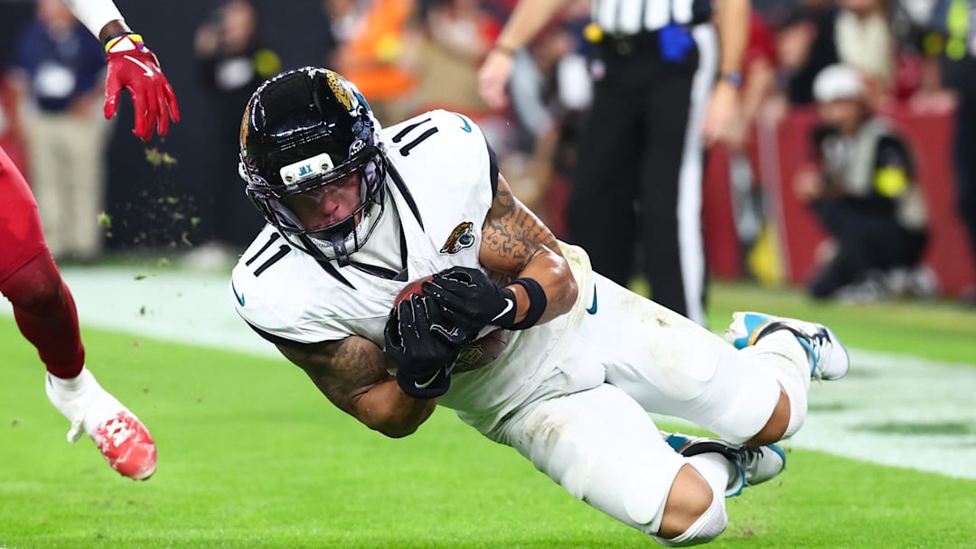 Nov 23, 2025; Glendale, Arizona, USA; Jacksonville Jaguars wide receiver Parker Washington (11) scores a touchdown as Arizona Cardinals cornerback Garrett Williams (21) defends during the fourth quarter at State Farm Stadium. Mandatory Credit: Mark J. Rebilas-Imagn Images