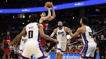 Apr 2, 2025; Washington, District of Columbia, USA; Washington Wizards forward Tristan Vukcevic (00) shoots the ball as Sacramento Kings center Jonas Valanciunas (17) and Kings forward Trey Lyles (41) defend in the second half at Capital One Arena. Mandatory Credit: Geoff Burke-Imagn Images