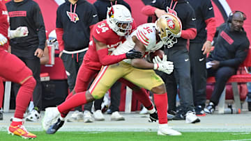 Jan 5, 2025; Glendale, Arizona, USA; Arizona Cardinals safety Jalen Thompson (34) tackes San Francisco 49ers running back Patrick Taylor Jr. (32) in the first half at State Farm Stadium. Mandatory Credit: Matt Kartozian-Imagn Images