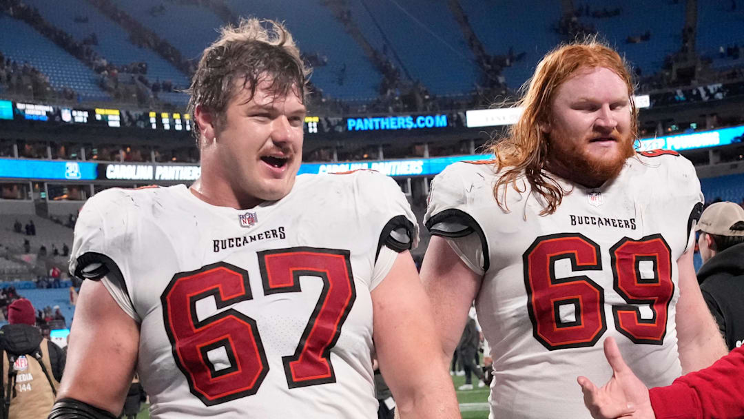 Dec 1, 2024; Charlotte, North Carolina, USA; Tampa Bay Buccaneers offensive tackle Luke Goedeke (67) and guard Cody Mauch (69) leave the field after the game at Bank of America Stadium. Mandatory Credit: Bob Donnan-Imagn Images