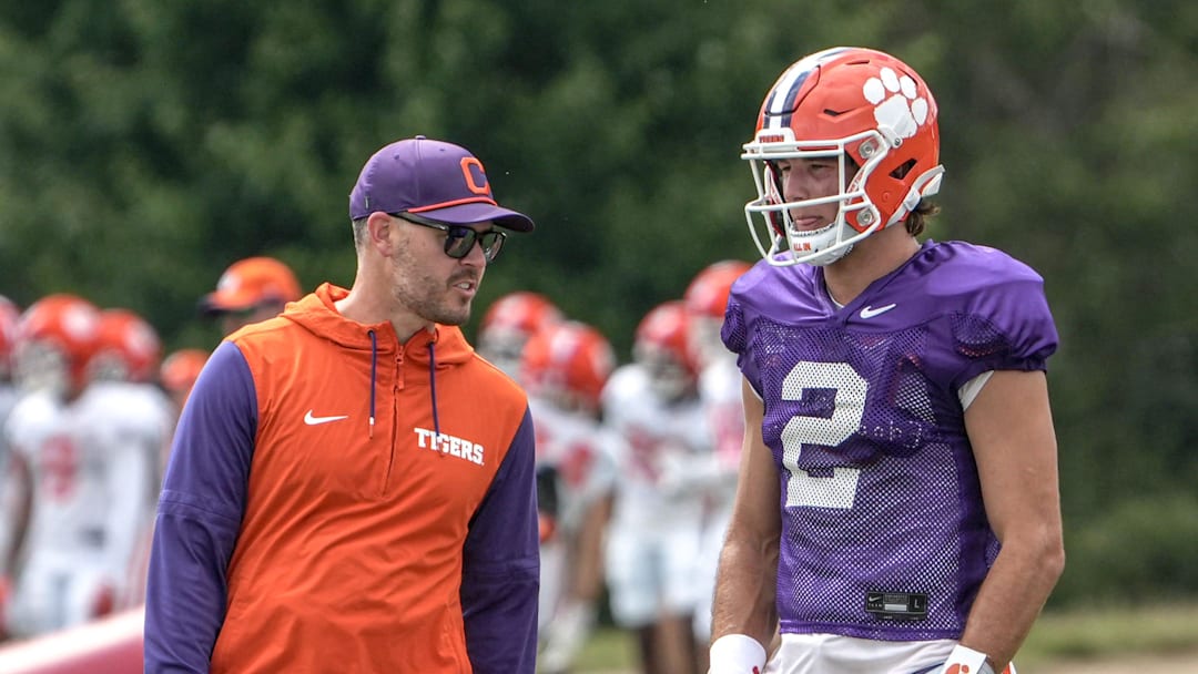 Clemson offensive coordinator Garrett Riley and quarterback Cade Klubnik (2) talk during Clemson football 2025 practice at Jervey Meadows in Clemson, S.C. Wednesday, August 6, 2025.