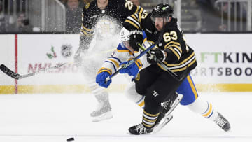 Dec 7, 2023; Boston, Massachusetts, USA; Boston Bruins left wing Brad Marchand (63) and Buffalo Sabres center Peyton Krebs (19) battle for the puck during the first period at TD Garden. Mandatory Credit: Bob DeChiara-USA TODAY Sports