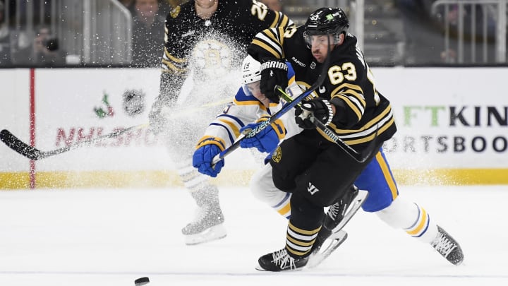 Dec 7, 2023; Boston, Massachusetts, USA; Boston Bruins left wing Brad Marchand (63) and Buffalo Sabres center Peyton Krebs (19) battle for the puck during the first period at TD Garden. Mandatory Credit: Bob DeChiara-USA TODAY Sports