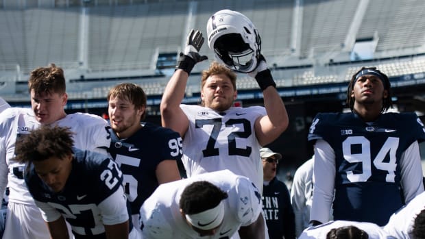 Penn State offensive lineman Nolan Rucci claps with his helmet after the playing of the alma mater during the Blue-White game