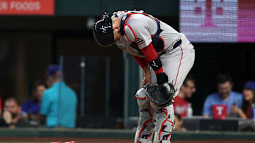 Mar 27, 2025; Arlington, Texas, USA; Boston Red Sox catcher Connor Wong (12) reacts after being hit with a foul ball during the second inning against the Texas Rangers at Globe Life Field. Mandatory Credit: Tim Heitman-Imagn Images