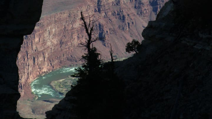 A nature-created hole in outcropping of rock called Angel's Window provides a look to the canyon walls beyond and the Colorado River at the Grand Canyon. Oct. 29 2021

Canyon Window Dark