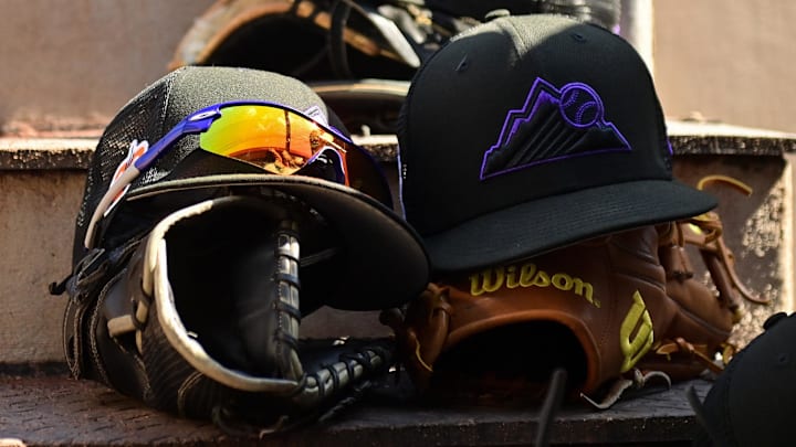 Mar 3, 2023; Scottsdale, Arizona, USA; A detail view of Colorado Rockies hats, gloves and glasses prior to the game against the San Francisco Giants during a Spring Training game at Scottsdale Stadium.