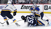 Apr 21, 2025; Winnipeg, Manitoba, CAN; Winnipeg Jets center Mark Scheifele (55) slides into St. Louis Blues goaltender Jordan Binnington (50) after being checked by St. Louis Blues defenseman Cam Fowler (17) in the second period in game two of the first round of the 2025 Stanley Cup Playoffs at Canada Life Centre. Mandatory Credit: James Carey Lauder-Imagn Images