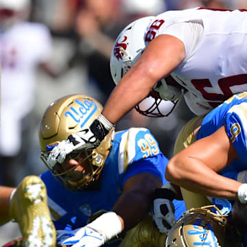 Oct 7, 2023; Pasadena, California, USA; UCLA Bruins defensive lineman Keanu Williams (99) recovers the fumble against the Washington State Cougars during the first half at Rose Bowl. Mandatory Credit: Gary A. Vasquez-Imagn Images