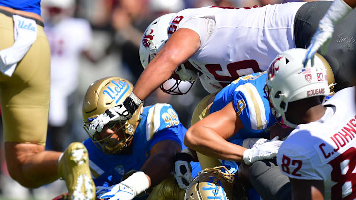 Oct 7, 2023; Pasadena, California, USA; UCLA Bruins defensive lineman Keanu Williams (99) recovers the fumble against the Washington State Cougars during the first half at Rose Bowl. Mandatory Credit: Gary A. Vasquez-Imagn Images