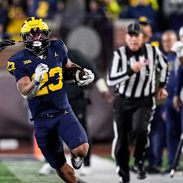 Michigan running back Jordan Marshall (23) runs against Purdue defensive back Tahj Ra-El (21) during the second half at Michigan Stadium in Ann Arbor on Saturday, November 1, 2025.