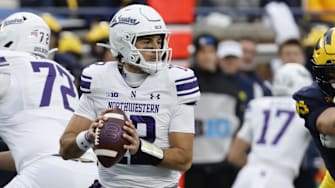 Nov 23, 2024; Ann Arbor, Michigan, USA;  Northwestern Wildcats quarterback Jack Lausch (12) drops back to pass against the Michigan Wolverines in the first half at Michigan Stadium. Mandatory Credit: Rick Osentoski-Imagn Images