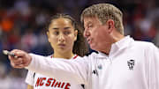 Mar 9, 2025; Greensboro, NC, USA;  NC State Wolfpack head coach Wes Moore talks with NC State Wolfpack guard Devyn Quigley (0) during the fourth quarter against Duke Blue Devils at First Horizon Coliseum. Mandatory Credit: Cory Knowlton-Imagn Images