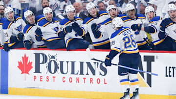 Apr 30, 2025; Winnipeg, Manitoba, CAN; St. Louis Blues forward Nathan Walker (26) is congratulated by his teammates on his goal against Winnipeg Jets goalie Connor Hellebuyck (37) during the first period in game five of the first round of the 2025 Stanley Cup Playoffs at Canada Life Centre. Mandatory Credit: Terrence Lee-Imagn Images