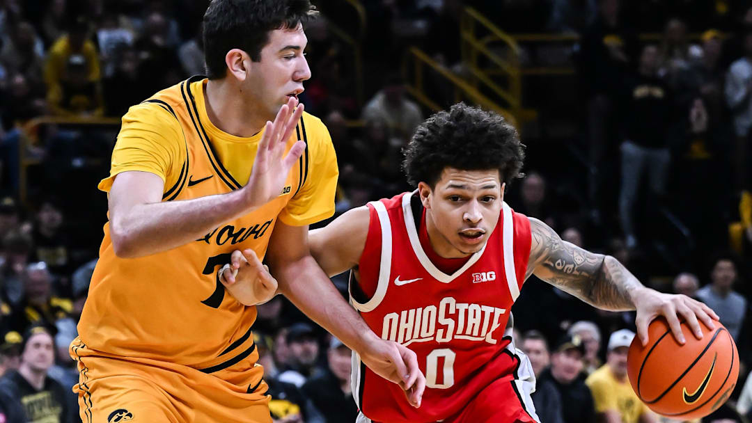 Feb 25, 2026; Iowa City, Iowa, USA; Ohio State Buckeyes guard John Mobley Jr. (0) controls the ball as Iowa Hawkeyes forward Alvaro Folgueiras (7) defends during the first half at Carver-Hawkeye Arena. Mandatory Credit: Jeffrey Becker-Imagn Images