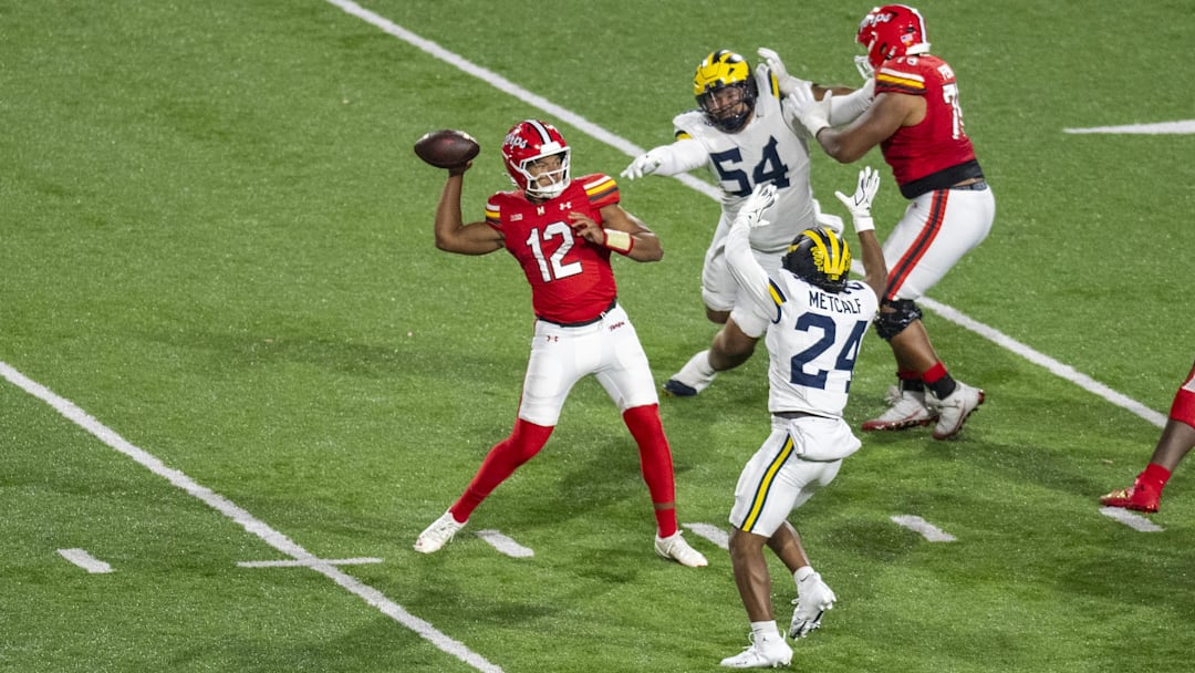 Maryland backup quarterback Khristian Martin throws under pressure from Michigan's Tevis Metcalf (24), defensive lineman Deyvid Palepale.
