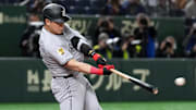 Mar 16, 2025; Bunkyo, Tokyo, Japan; Yomiuri Giants first baseman Kazuma Okamoto (25) hits a single against the Chicago Cubs during the second inning at Tokyo Dome. Mandatory Credit: Darren Yamashita-Imagn Images