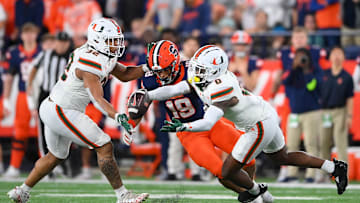 Nov 30, 2024; Syracuse, New York, USA; Miami Hurricanes linebacker Raul Aguirre Jr. (32) and defensive back Mishael Powell (0) break up a pass intended for Syracuse Orange tight end Oronde Gadsden II (19) during the first half at the JMA Wireless Dome. Mandatory Credit: Rich Barnes-Imagn Images