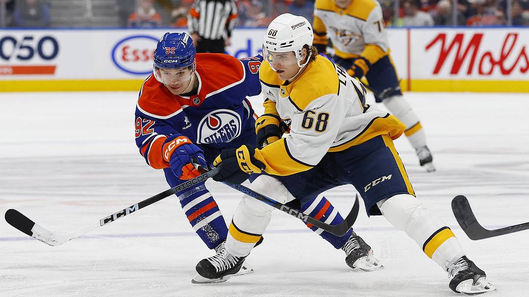 Nov 14, 2024; Edmonton, Alberta, CAN; Nashville Predators forward Zach L'Heureux (68) tries to move the puck past Edmonton Oilers forward Vasily Podkolzin (92) during the second period at Rogers Place. Mandatory Credit: Perry Nelson-Imagn Images