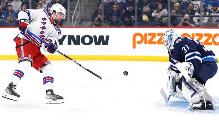 Oct 30, 2023; Winnipeg, Manitoba, CAN; New York Rangers left wing Alexis Lafreniere (13) shoots on Winnipeg Jets goaltender Connor Hellebuyck (37) in the first period at Canada Life Centre. Mandatory Credit: James Carey Lauder-USA TODAY Sports