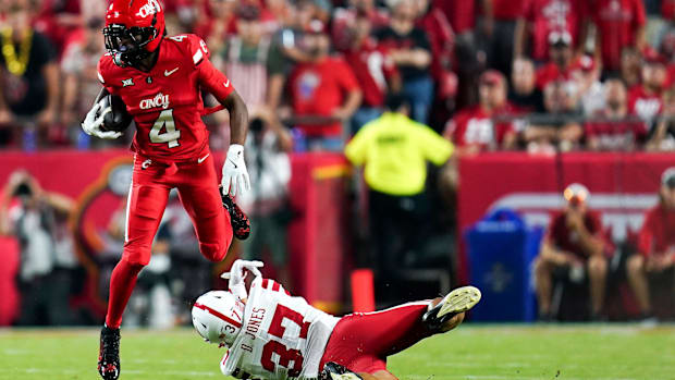 Cincinnati Bearcats wide receiver Cyrus Allen tries to evade Nebraska defensive back Donovan Jones (37) in season opener.