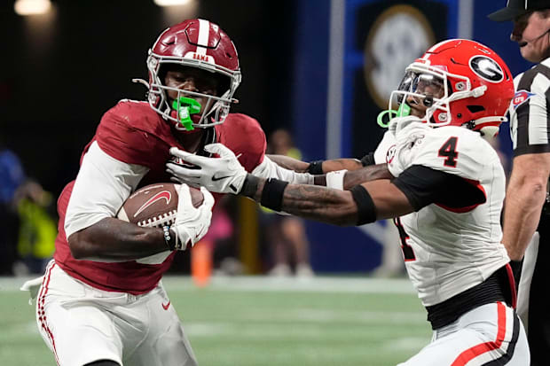 Alabama wide receiver Germie Bernard uses a stiff-arm to break a tackle by Georgia defensive back KJ Bolden.