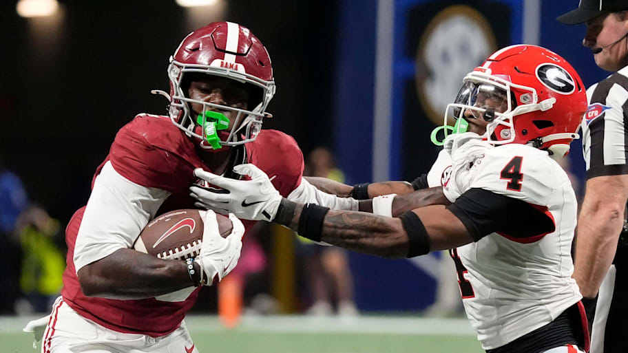 Alabama wide receiver Germie Bernard uses a stiff-arm to break a tackle by Georgia defensive back KJ Bolden.