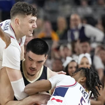 Connecticut Huskies center Donovan Clingan (32) and guard Stephon Castle (5) battle Purdue Boilermakers center Zach Edey (15) for the ball during the Men's NCAA national championship game at State Farm Stadium in Glendale on April 8, 2024.