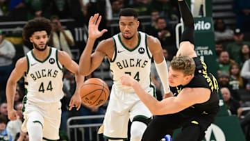 Utah Jazz forward Lauri Markkanen reaches for the ball against  Milwaukee Bucks forward Giannis Antetokounmpo and forward Andre Jackson Jr. in the first quarter at Fiserv Forum on Thursday.