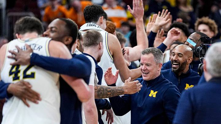Michigan head coach Dusty May high-fives players to celebrate 95-62 win over Tennessee at the NCAA Tournament Elite 8 round at United Center in Chicago on Sunday, March 29, 2026.