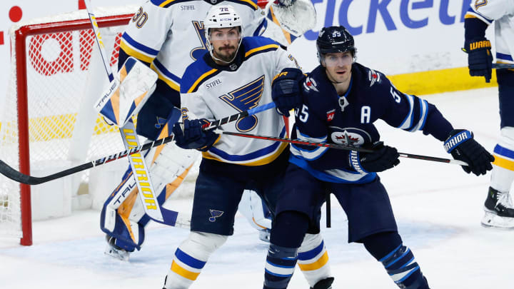 Feb 27, 2024; Winnipeg, Manitoba, CAN; St. Louis Blues defenseman Justin Faulk (72) jostles for position with Winnipeg Jets forward Mark Scheifele (55) in front of St. Louis Blues goalie Joel Hofer (30) during the third period at Canada Life Centre. Mandatory Credit: Terrence Lee-USA TODAY Sports