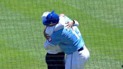 Kansas City Royals catcher Salvador Perez hugs his mom Yilda Diaz after she threw out the ceremonial first pitch.