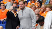 A Tennessee fan takes a photos with Tennessee football coach Josh Heupel at the NCAA Tournament Elite Eight game between Tennessee and Houston at Lucas Oil Stadium in Indianapolis, Ind., on Sunday, March 30, 2025.