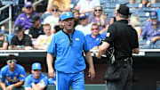 Jun 17, 2025; Omaha, Neb, USA;  UCLA Bruins head coach John Savage (22) discusses a call with the plate umpire during the game against the LSU Tigers during the seventh inning at Charles Schwab Field. Mandatory Credit: Steven Branscombe-Imagn Images