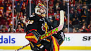 Nov 19, 2024; Calgary, Alberta, CAN; Calgary Flames goaltender Dustin Wolf (32) celebrate win with teammates after defeating New York Islanders at Scotiabank Saddledome. Mandatory Credit: Sergei Belski-Imagn Images