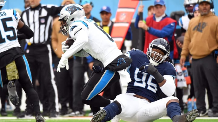 Nov 26, 2023; Nashville, Tennessee, USA; Tennessee Titans defensive end Denico Autry (96) tackles Carolina Panthers running back Miles Sanders (6) for a loss during the first half at Nissan Stadium. Mandatory Credit: Christopher Hanewinckel-USA TODAY Sports